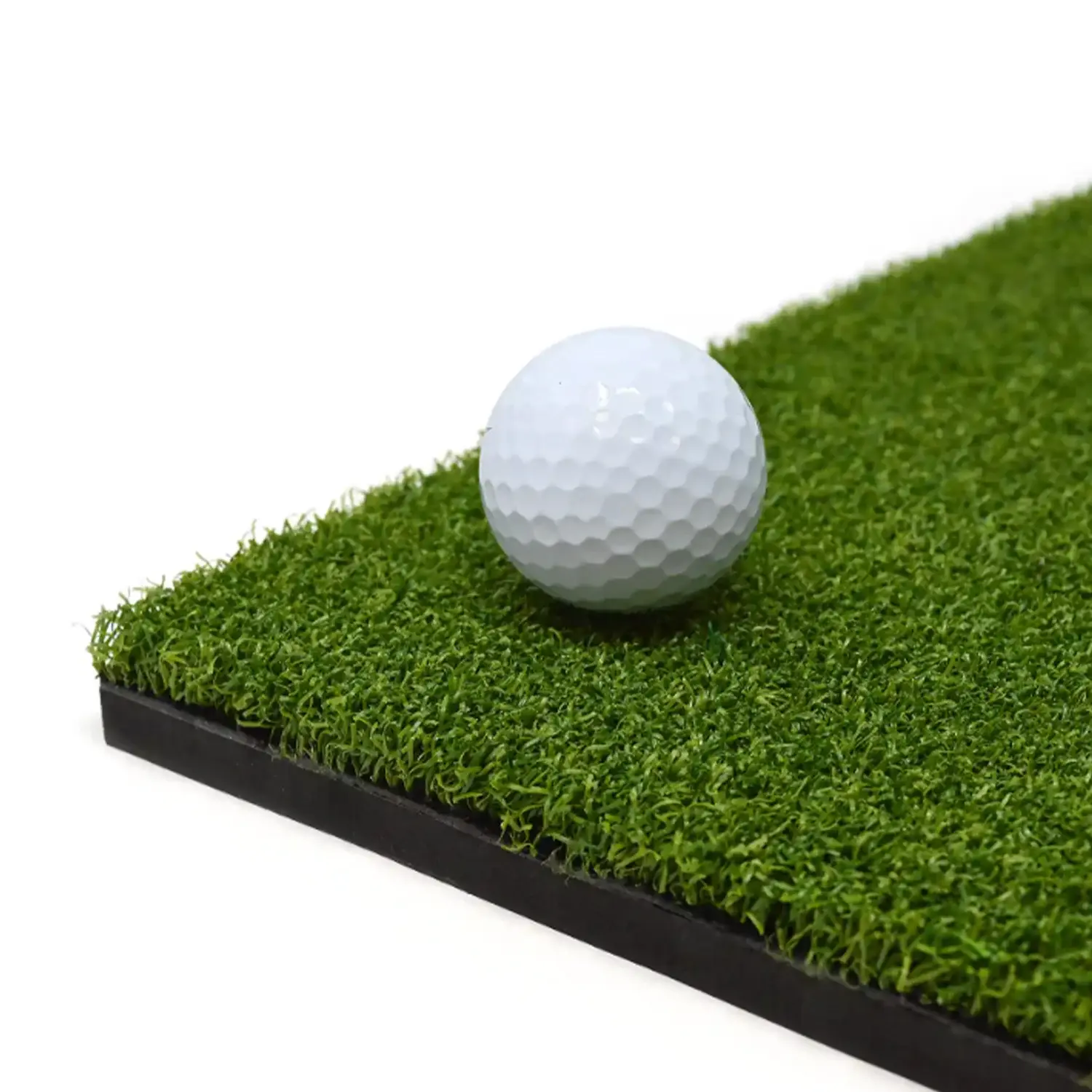 En vit golfboll ligger stilla på en konstgräsmatta med svart kant mot vit bakgrund.