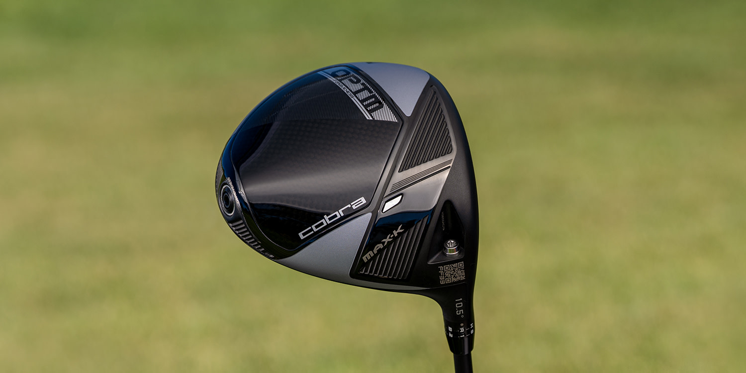 Golfklubba av märket Cobra, modell MAX-X, hålls upp mot en suddig grön bakgrund.